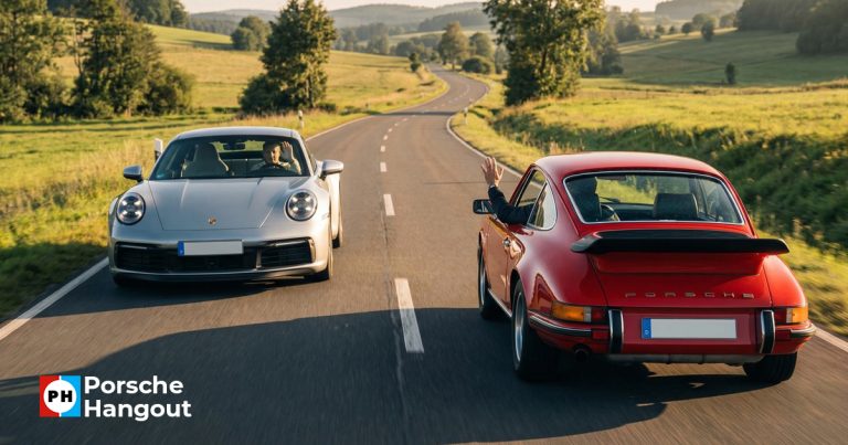 Two Porsche 911s - one classic and one modern - passing each other on a country road with drivers exchanging the Porsche Wave